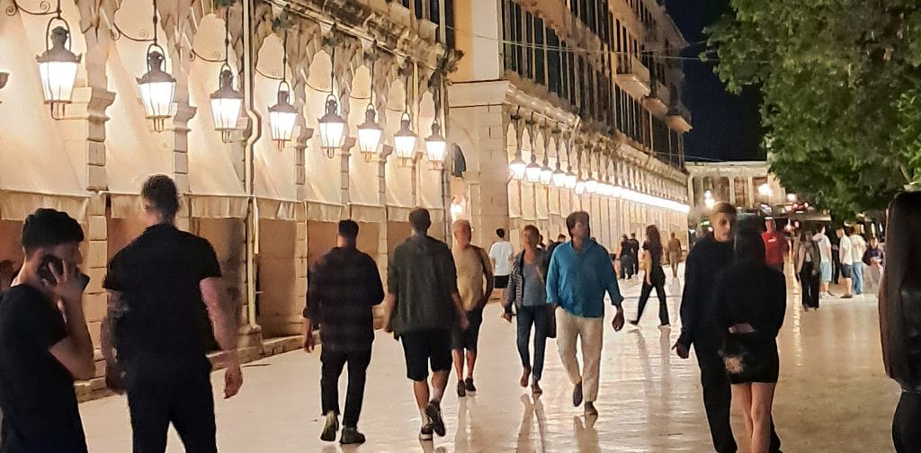 The Liston arcaded promenade in Corfu Town at night, lit by lanterns along the French-built colonnade